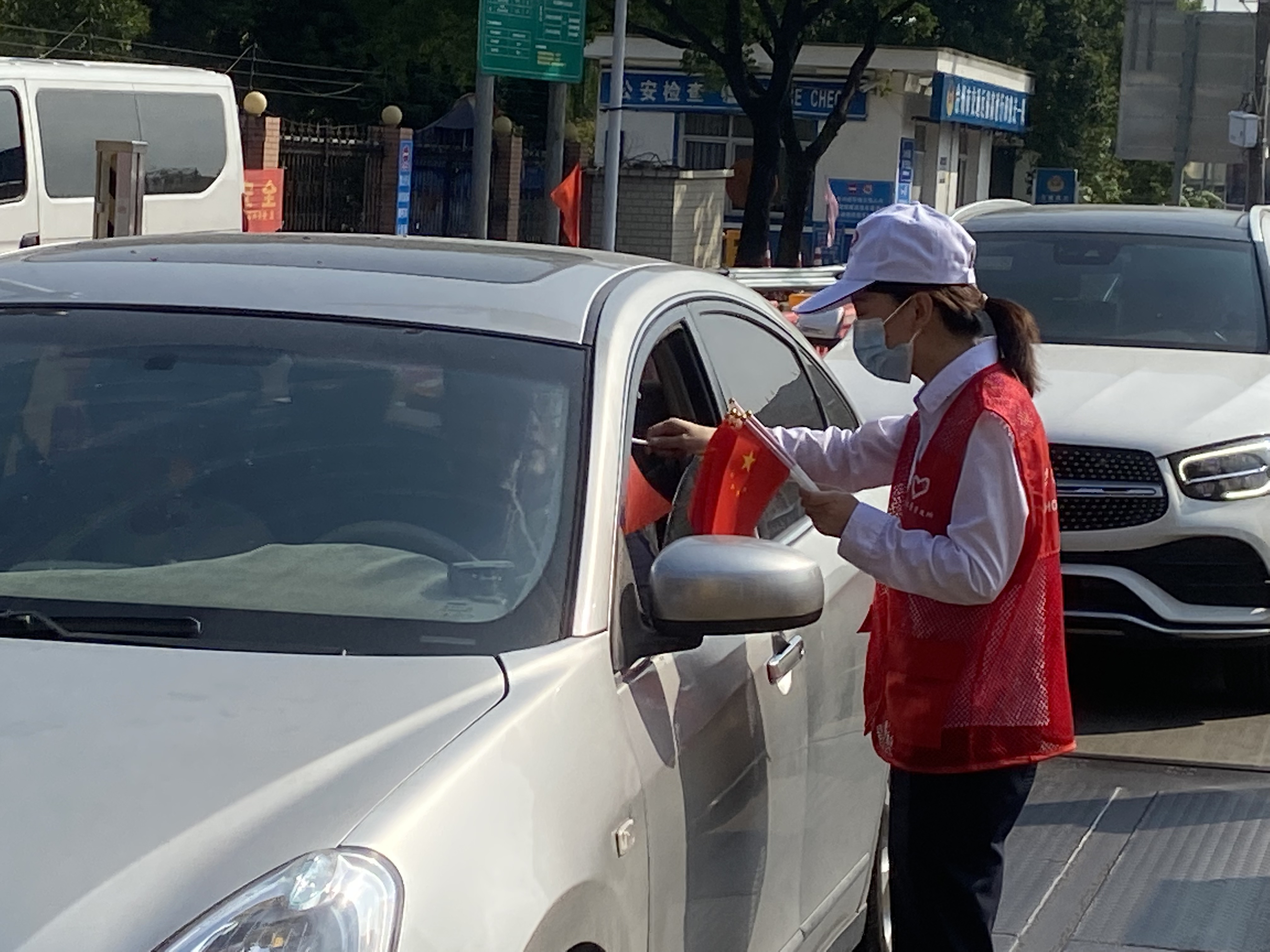 1665389692395867.jpg 志愿者分發小紅旗并宣傳林玲攝.jpg